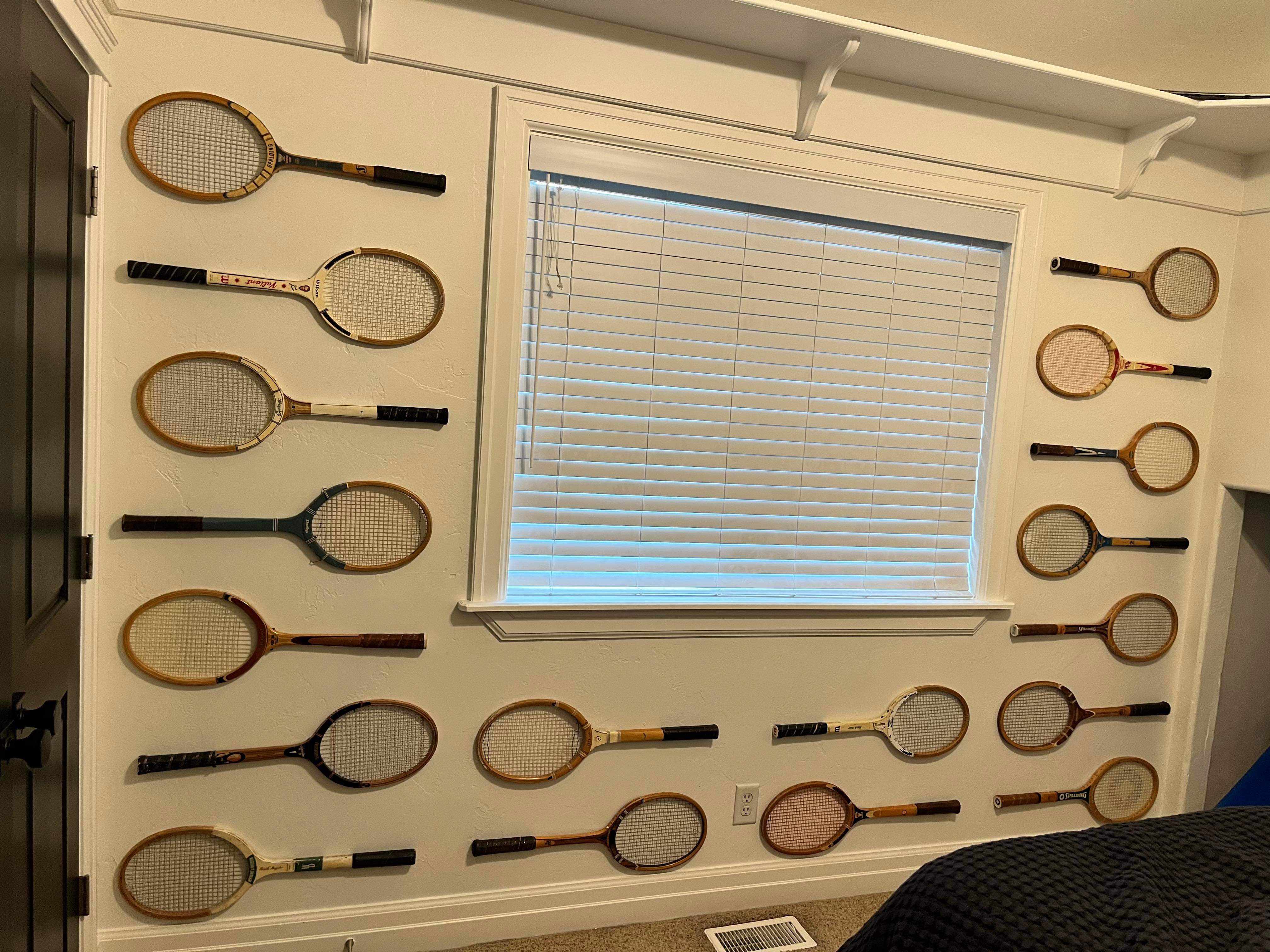 Vintage wood tennis rackets as gallery wall decor displayed in bedroom